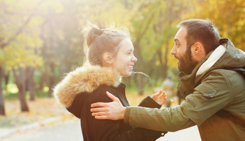 A man and woman hugging in the park.