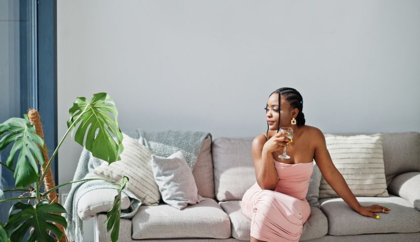 A woman sitting on a couch holding a glass of wine.