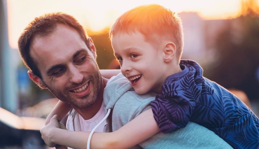 A man carries a young boy in his arms.