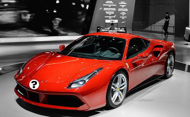 A red ferrari sports car is on display in a showroom.