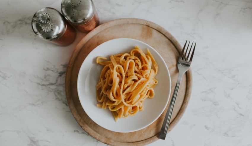 A plate of noodles and a fork.