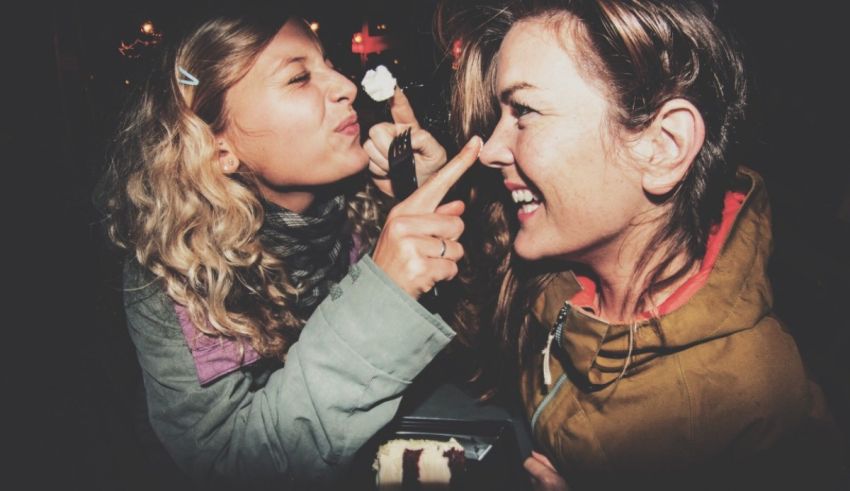 Two women are eating ice cream at a party.