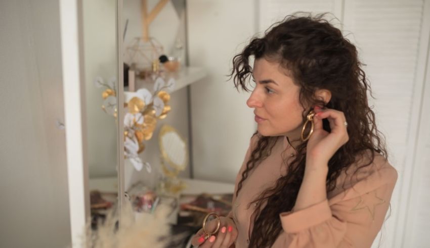 A woman in a pink dress standing in front of a mirror.