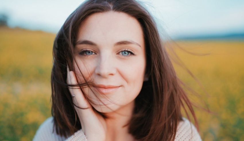 A woman is standing in a field of yellow flowers.