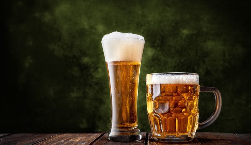 Two glasses of beer on a wooden table.