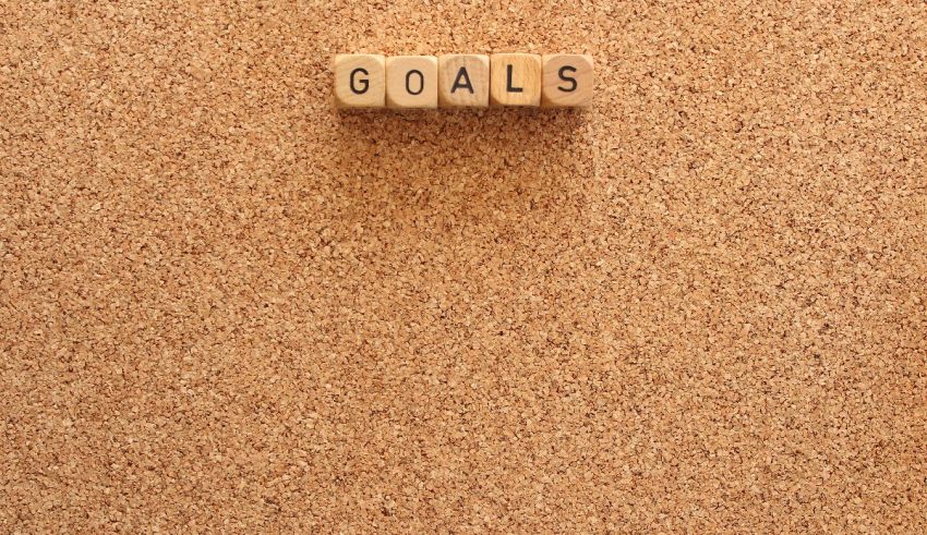 A cork board with the word goals written on it.