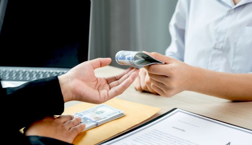 A man is giving money to a woman at a desk.