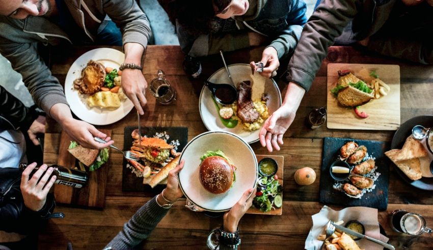 A group of people sitting around a table eating food.