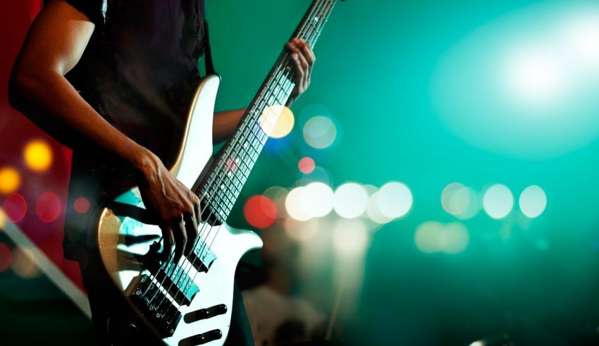 A man playing a bass guitar at a concert.