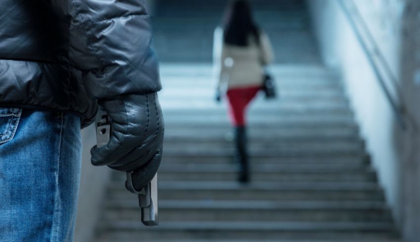 A man is holding a gun as he walks down the stairs.