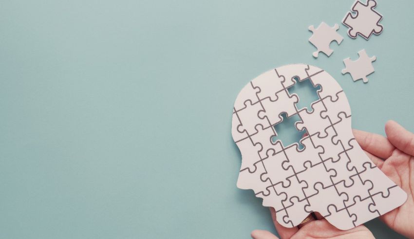 A person's hand holding a puzzle piece with a person's head on it.