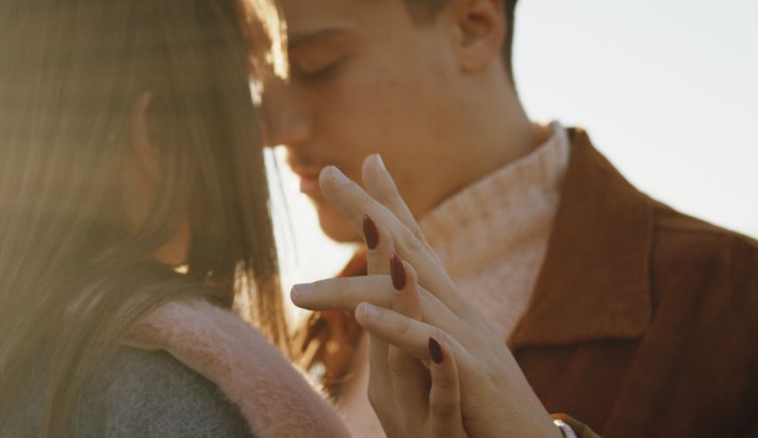 A man and woman kissing in the sun.