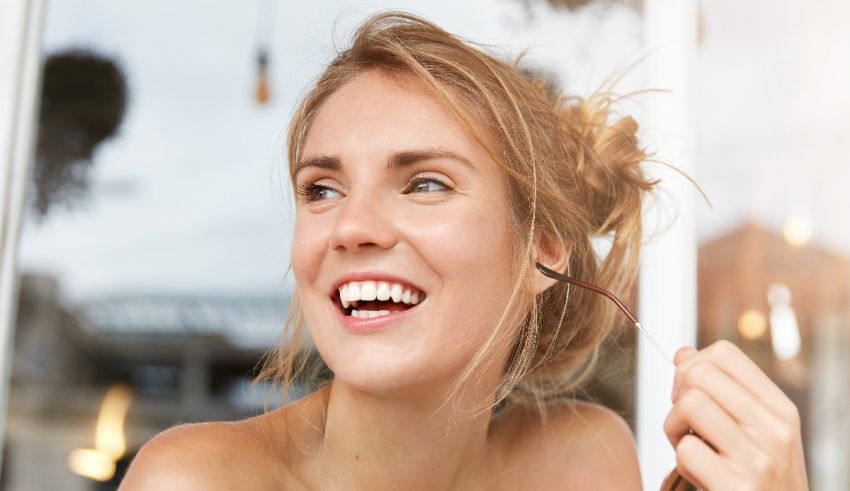 A woman is smiling while looking out of a window.