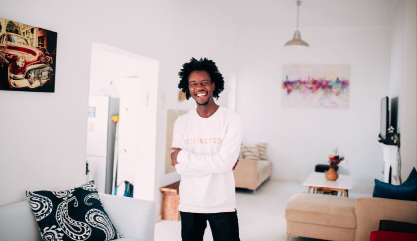 A young man in a white shirt standing in a living room.