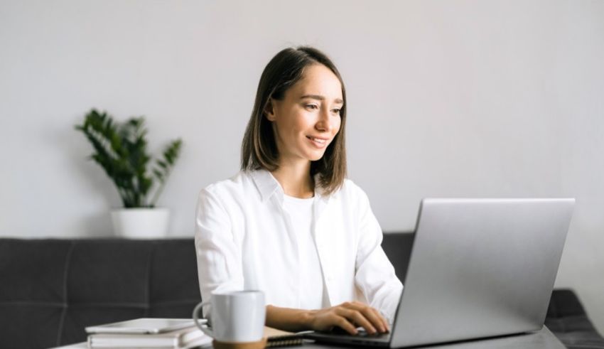 A woman sitting at a desk using a laptop.