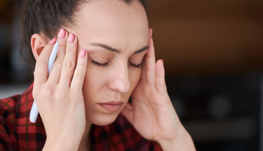 A woman touching her head with a pen.