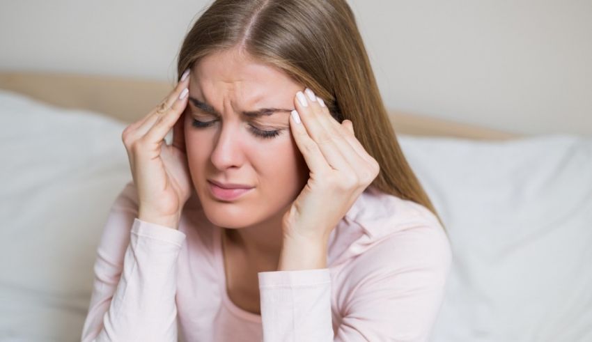 A woman with a headache in bed.