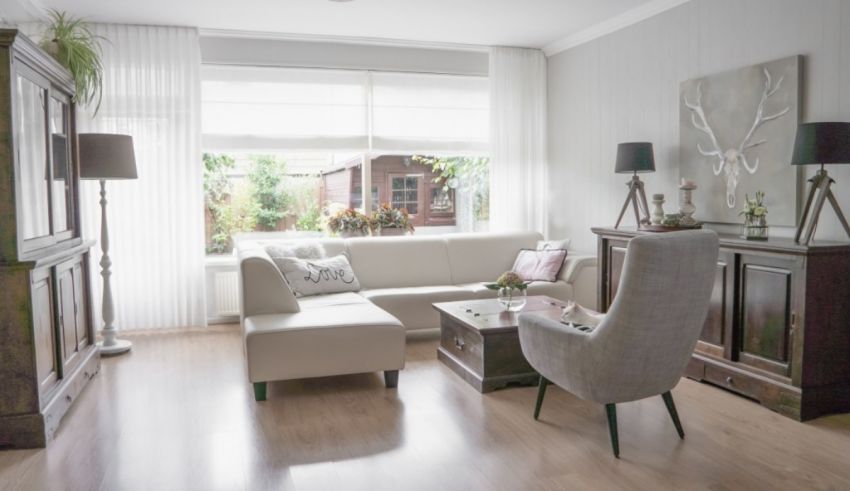 A living room with white furniture and wooden floors.