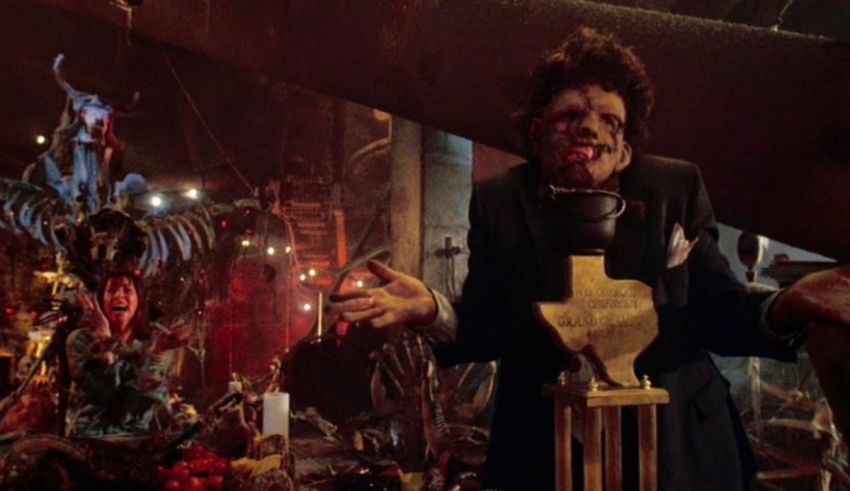 A man holding a trophy in a room full of statues.