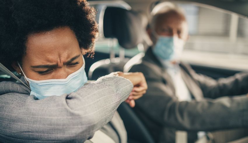 A woman wearing a face mask in a car.