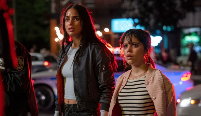 Two women standing next to each other on a street.