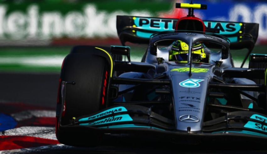 A mercedes f1 car driving on a track.