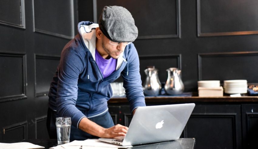 A man working on a laptop in a coffee shop.