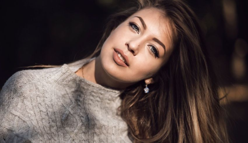 A young woman in a sweater posing for a photo.