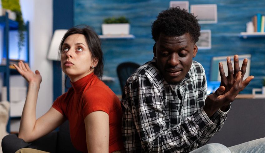 A man and woman sitting on a couch in a living room.