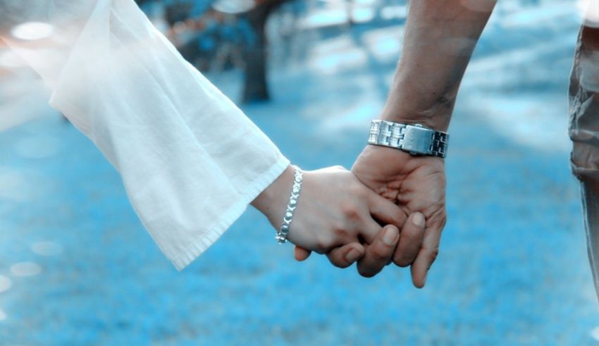 A man and woman holding hands in a field.