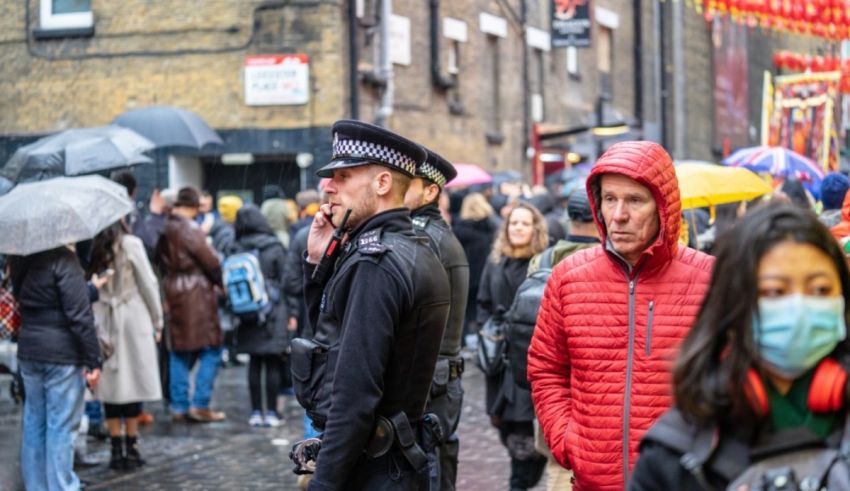 A group of people wearing masks and umbrellas on a rainy day in london.