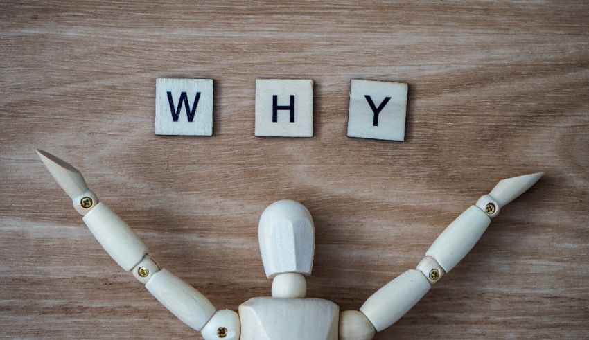 A wooden mannequin with the word why written on it.