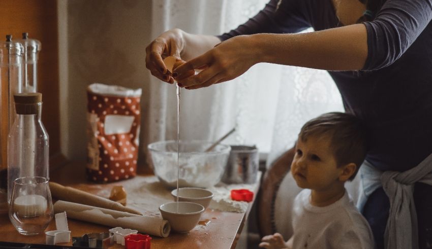 A mother and child making cookies in the kitchen.