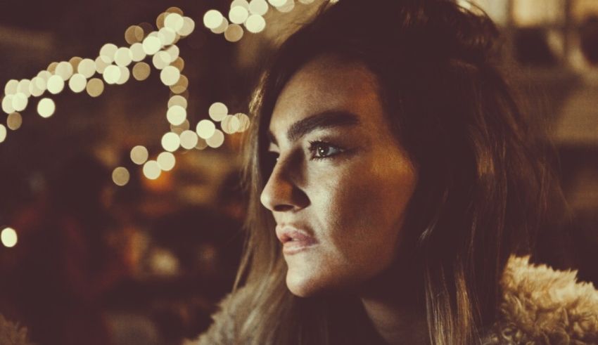 A woman in a fur coat standing in front of lights.
