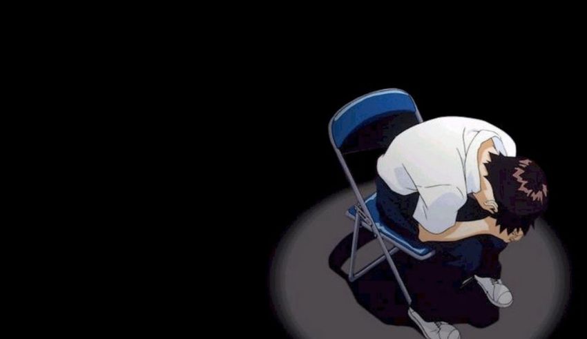 A man sitting on a chair with his head down.