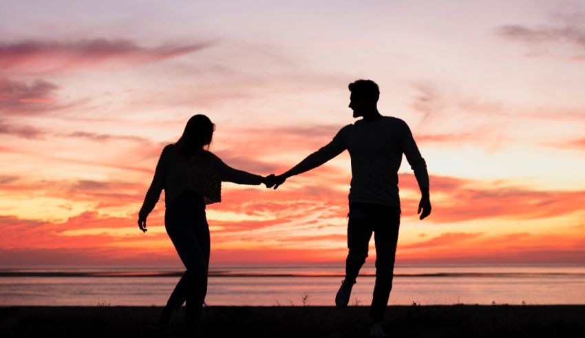 Silhouette of a couple holding hands at sunset.