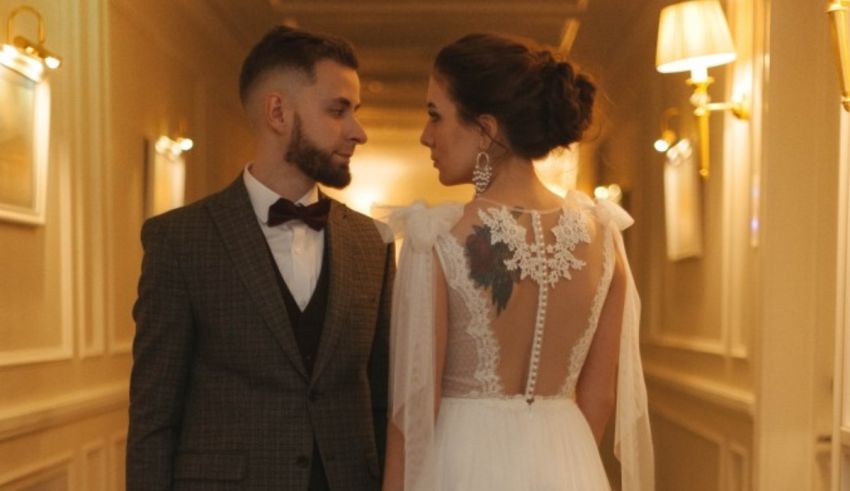 A bride and groom look at each other in a hallway.