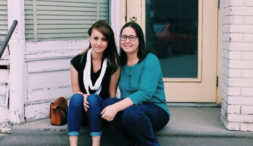 Two women sitting on the steps of a building.