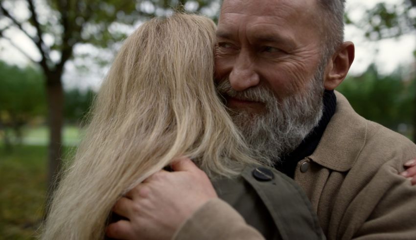 A man with a beard is hugging a woman.