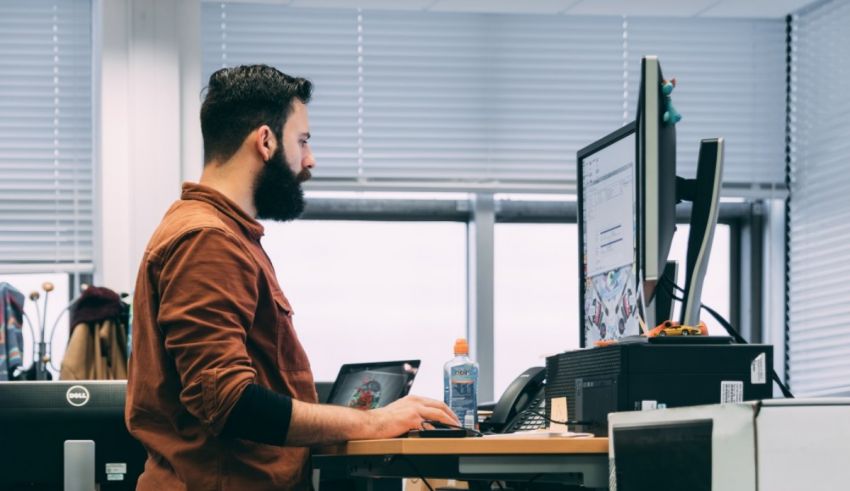 A man with a beard working at a desk.
