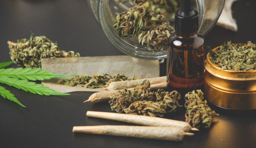 Cbd oil and cannabis leaves on a table.