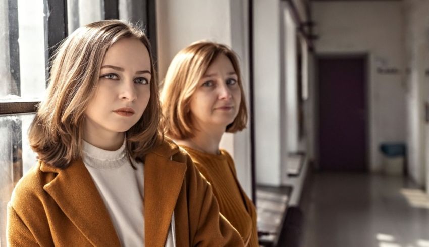 Two young women standing in a hallway.