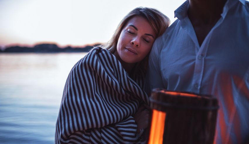 A man and a woman holding a fire pit on a lake.