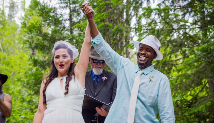 A bride and groom celebrating their wedding in the woods.