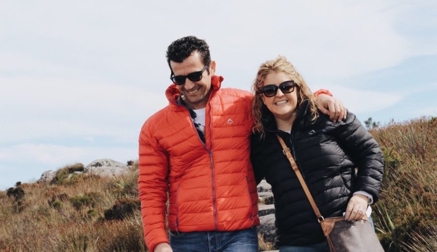 A man and a woman standing on a hill.