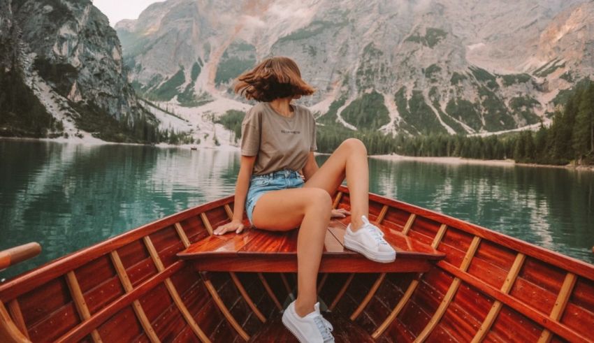 A woman is sitting on the back of a boat in a lake.