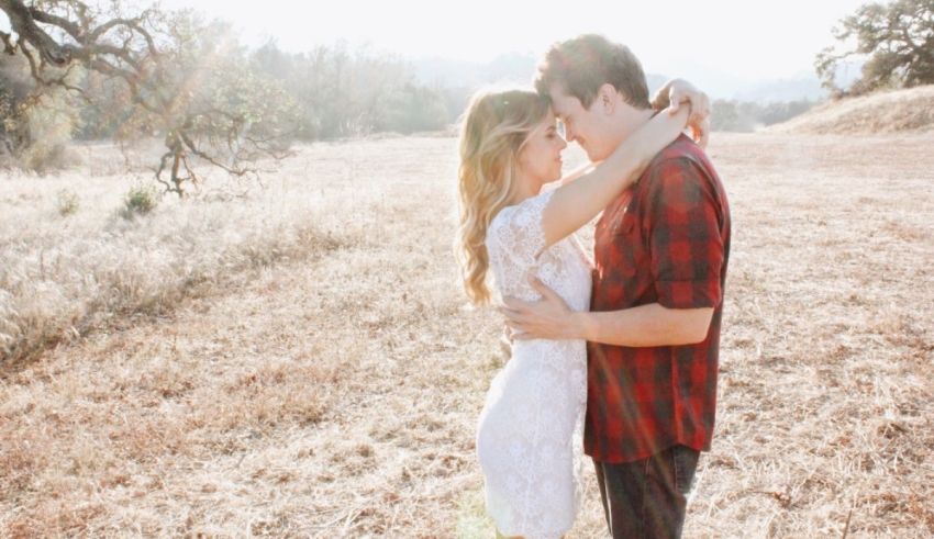 A couple embracing in the middle of a field.