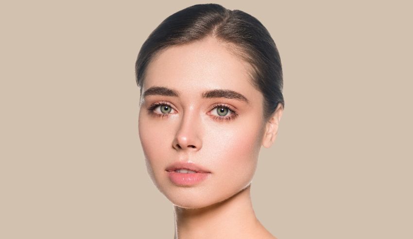 A woman is posing for a photo in front of a beige background.