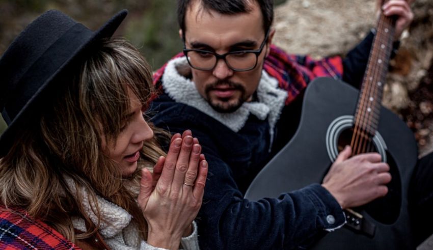 A man and woman playing an acoustic guitar.