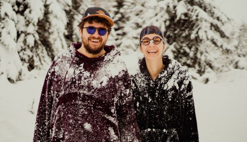 A man and woman standing in the snow.